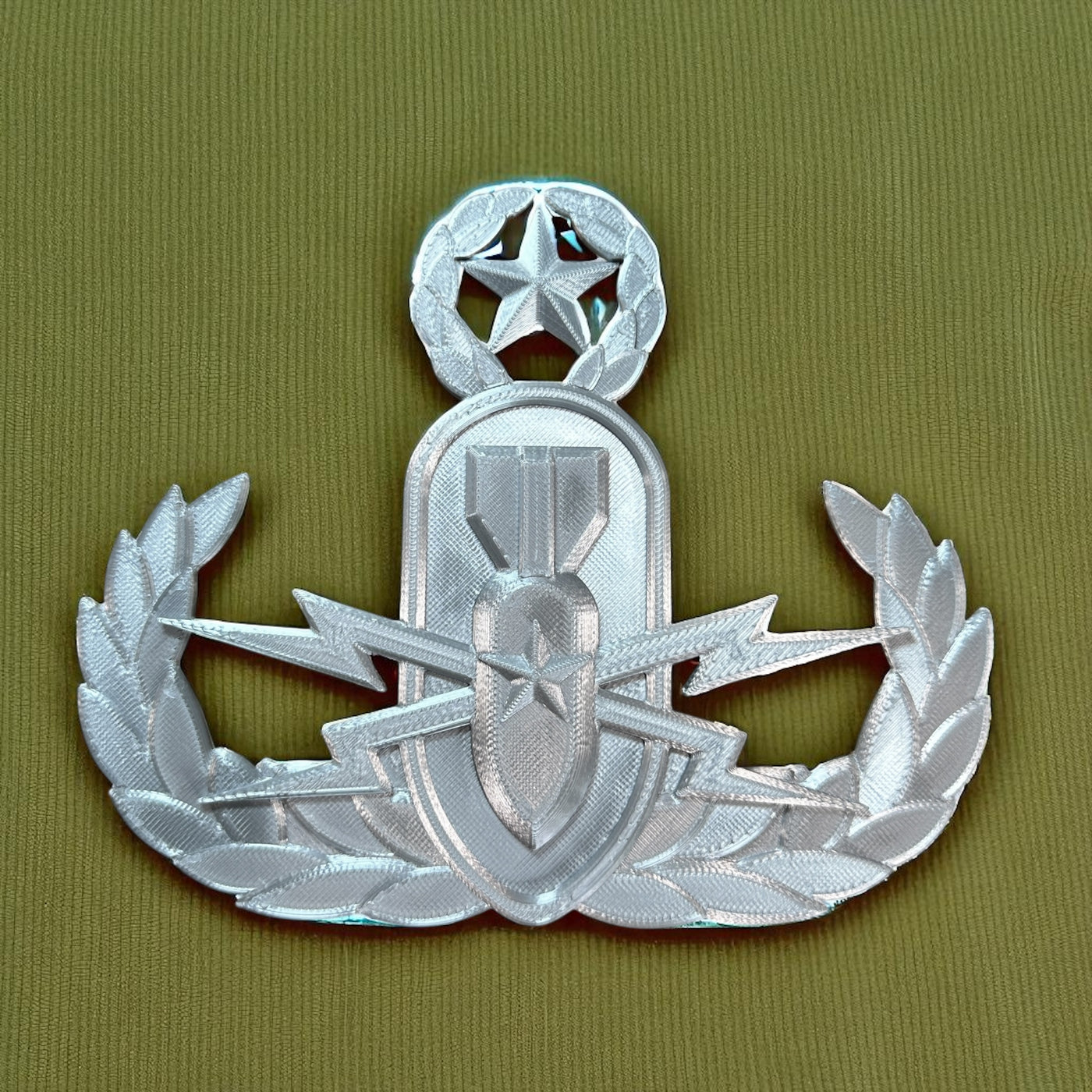 Replica EOD Badge Display with Master Level insignia on fabric background