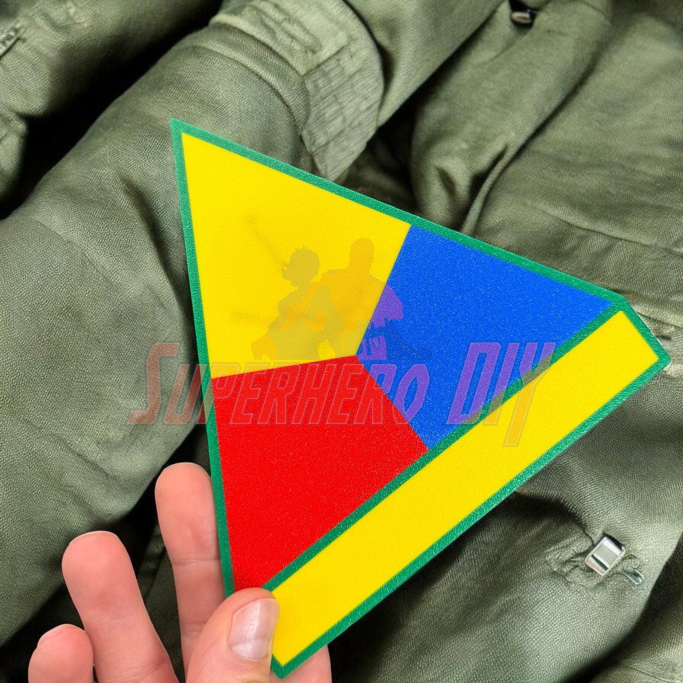 1st Armored Division display insignia held in hand, featuring colorful triangular design on military fabric.