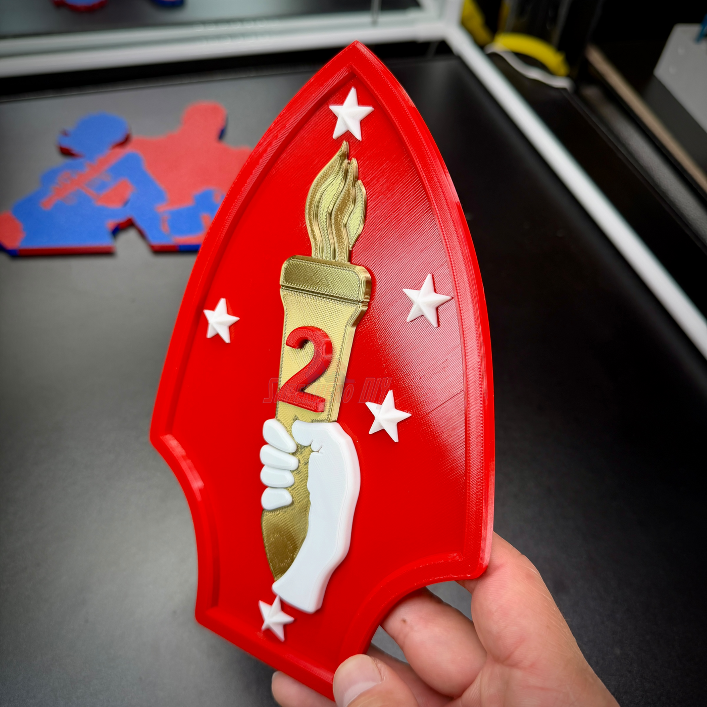 2nd Marine Division display insignia featuring a gold torch and red spearhead, ideal for wall displays.