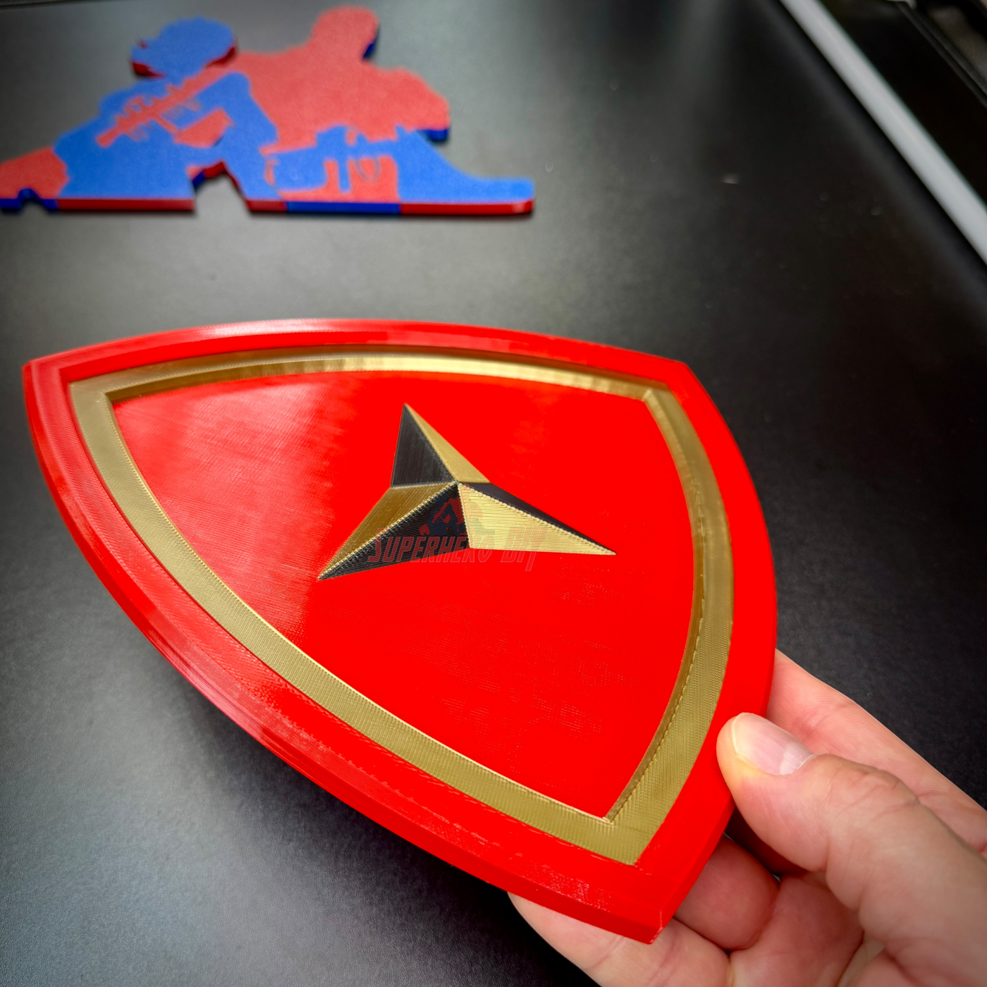 3rd Marine Division display insignia in bright red with gold border, held by a hand.