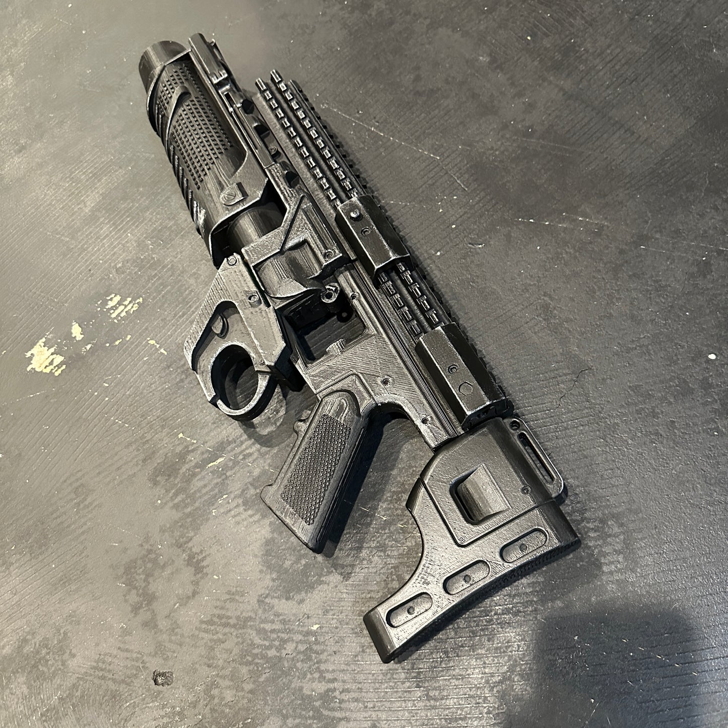 BvS Grenade Launcher Prop Batman v Superman displayed on a black surface, featuring a sleek 3D printed design.