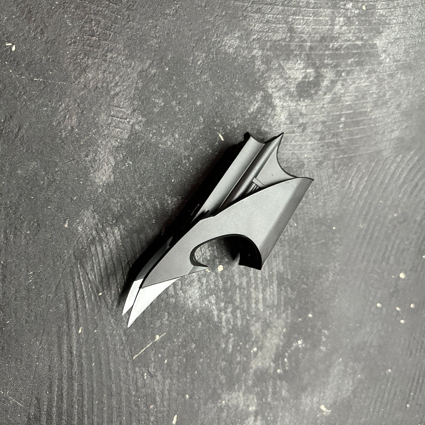 NECA BATMAN 1989 Folding Magnetic Batarang (LOOSE) displayed on a dark surface, showcasing its detailed design.