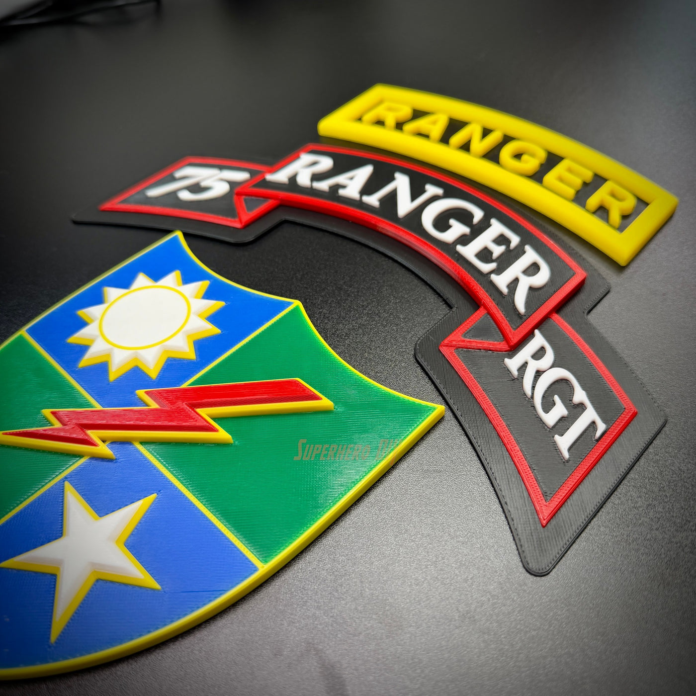 75th Ranger Regiment display insignia featuring colorful patches and tabs on a black background.