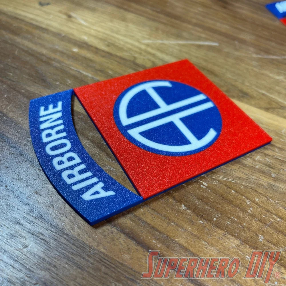 3D-printed 82nd Airborne Division display insignia in multiple sizes on wooden surface