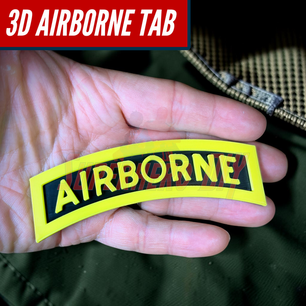 3D airborne tab resting in a hand, featuring bold yellow lettering on a solid black background.