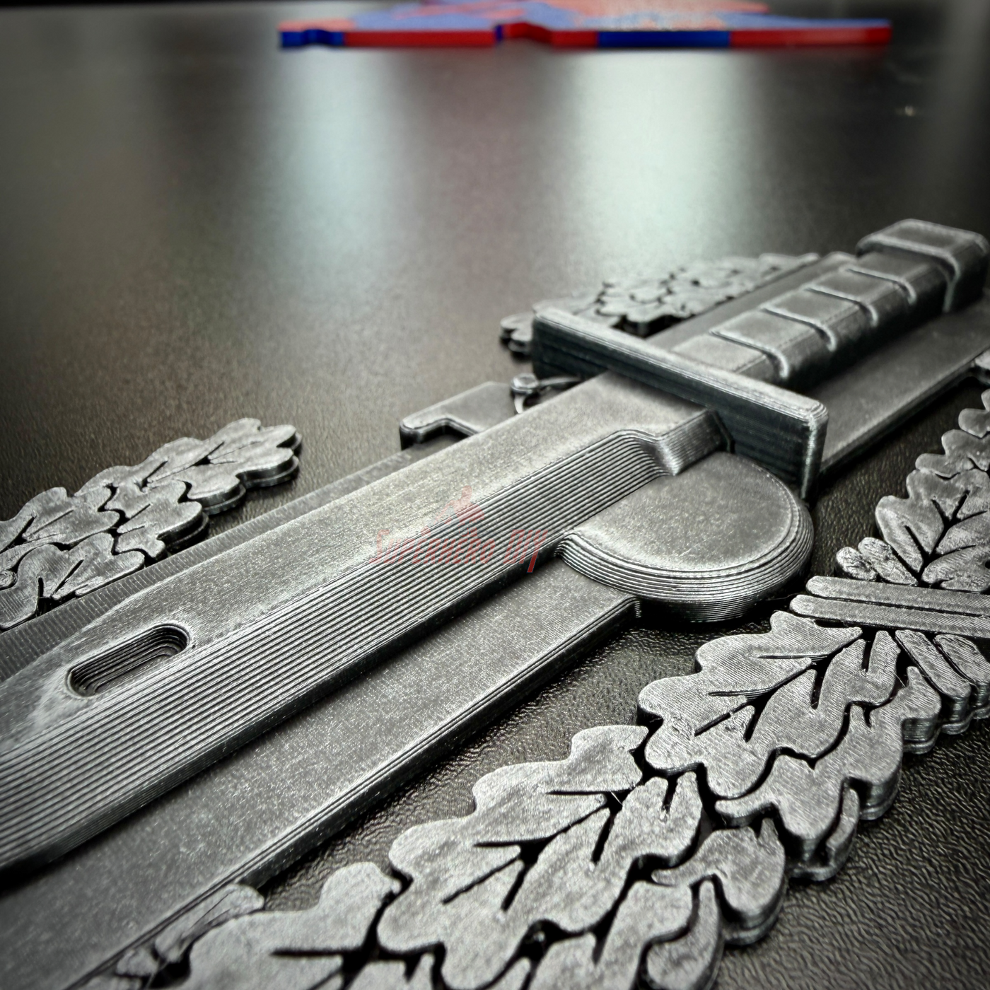 Close-up of combat action badge display insignia with pewter finish and detailed leaf design.