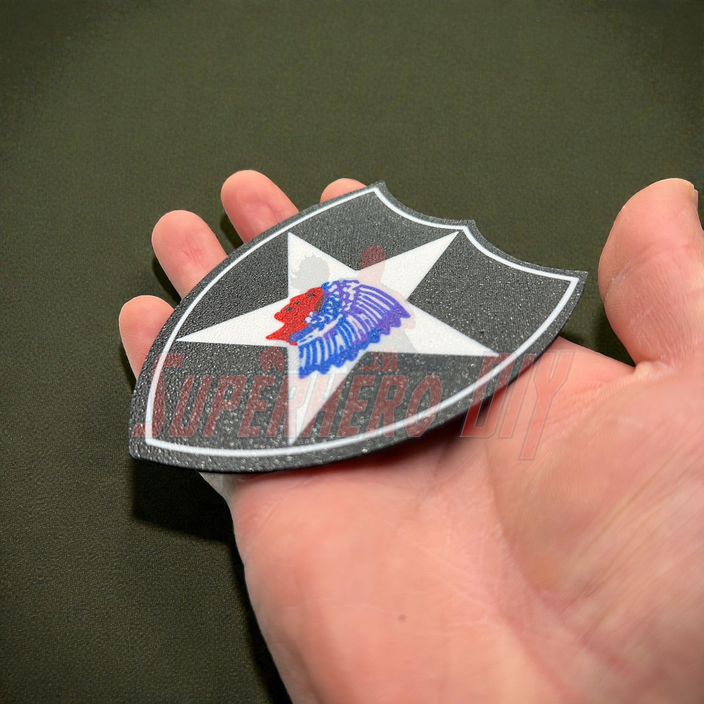 Hand holding 3D-printed 2nd Infantry Division display insignia patch for military shadowbox or wall display.