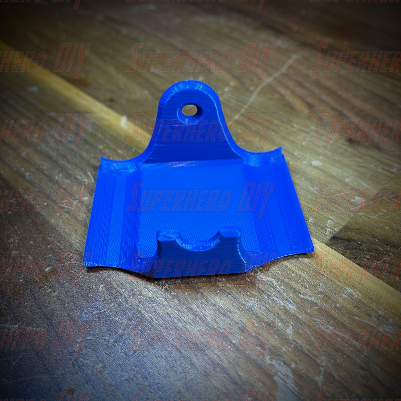 Blue PS4 controller wall mount on wooden surface, fits DualShock, includes Command Strip for easy installation.