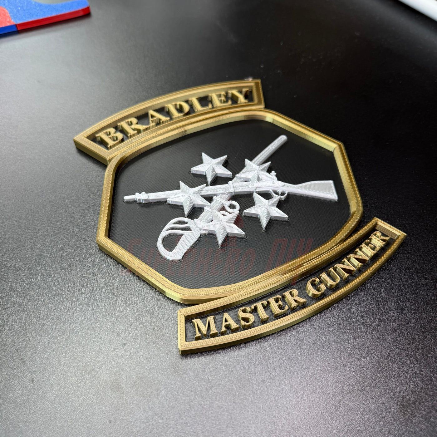 Bradley Master Gunner Badge display featuring crossed weapons and stars, ideal for a wall or desk.