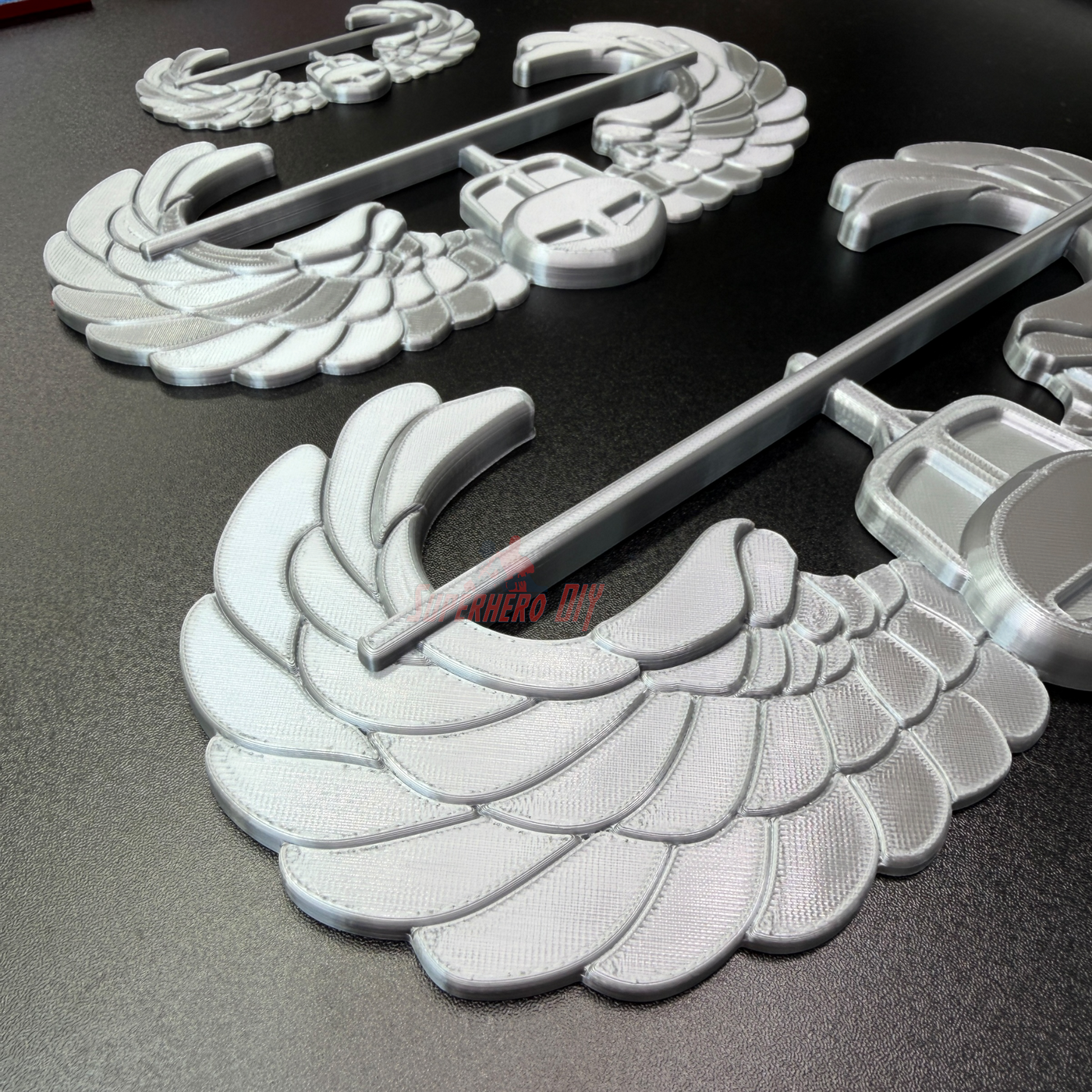 Air Assault Badge display insignia components in shiny silver finish on a black surface.
