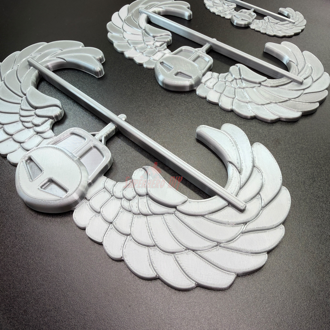 Air Assault Badge display insignia featuring shiny silver wings and helmet, ideal for military badge showcases.