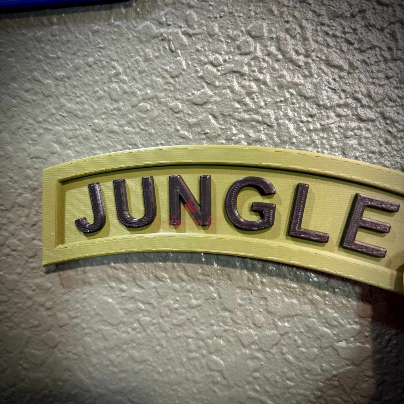 JUNGLE lettering on a wall-ready jungle tab display piece with an army green background.