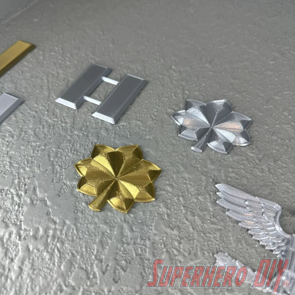 O-4 Major Navy lieutenant commander rank insignia in gold and silver finishes displayed on textured surface.
