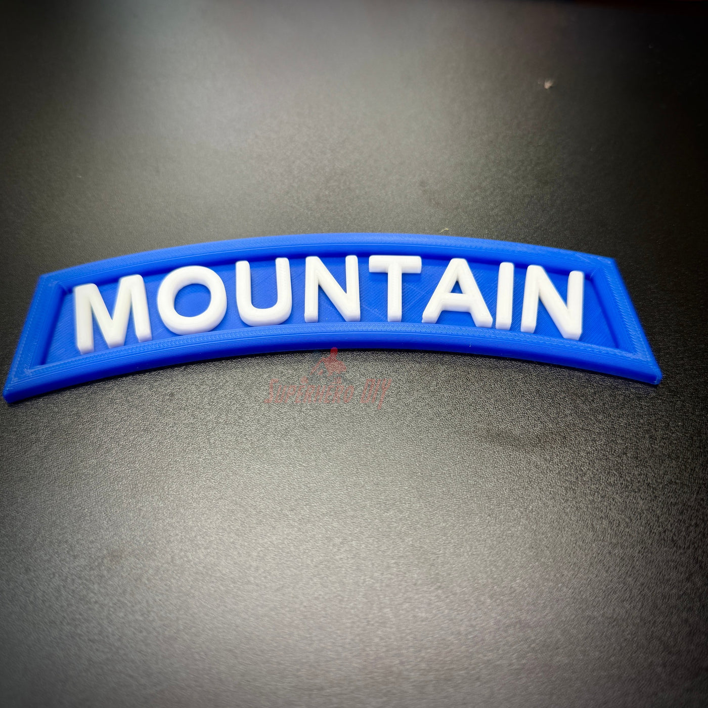 3D mountain tab wall display with raised white lettering on a deep blue background, designed for wall hanging.