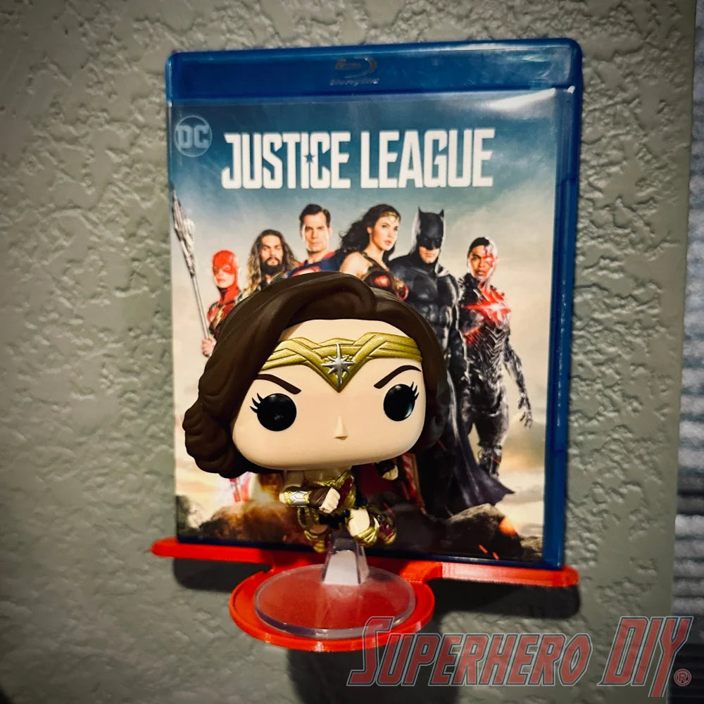 Justice League Blu-ray displayed with Wonder Woman Funko on wall mount media and funko display shelf.
