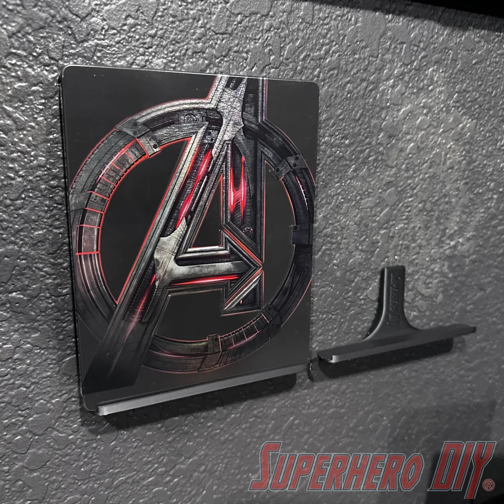 Floating shelf for movies or video games displaying a superhero-themed Blu-ray with included command strip on a wall.