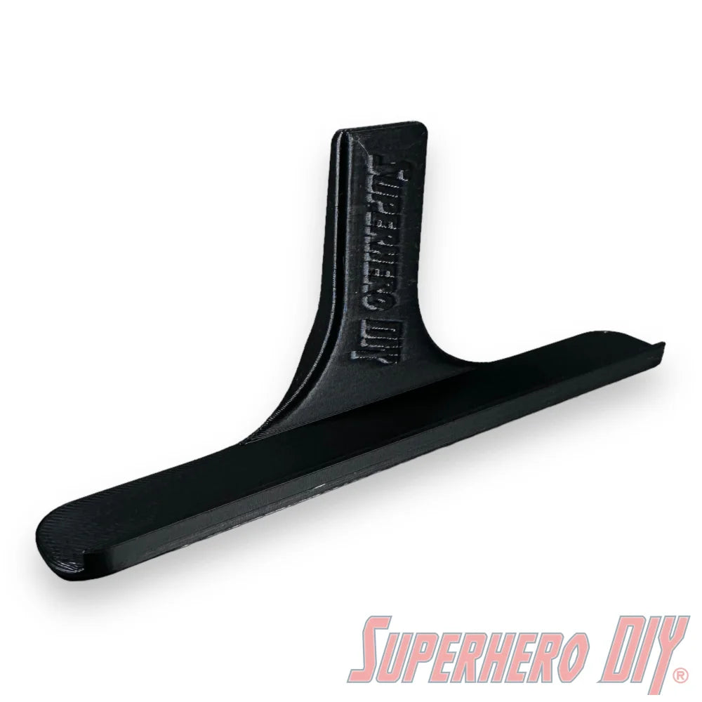 Black floating shelf for movies or video games with Command strip for wall display.