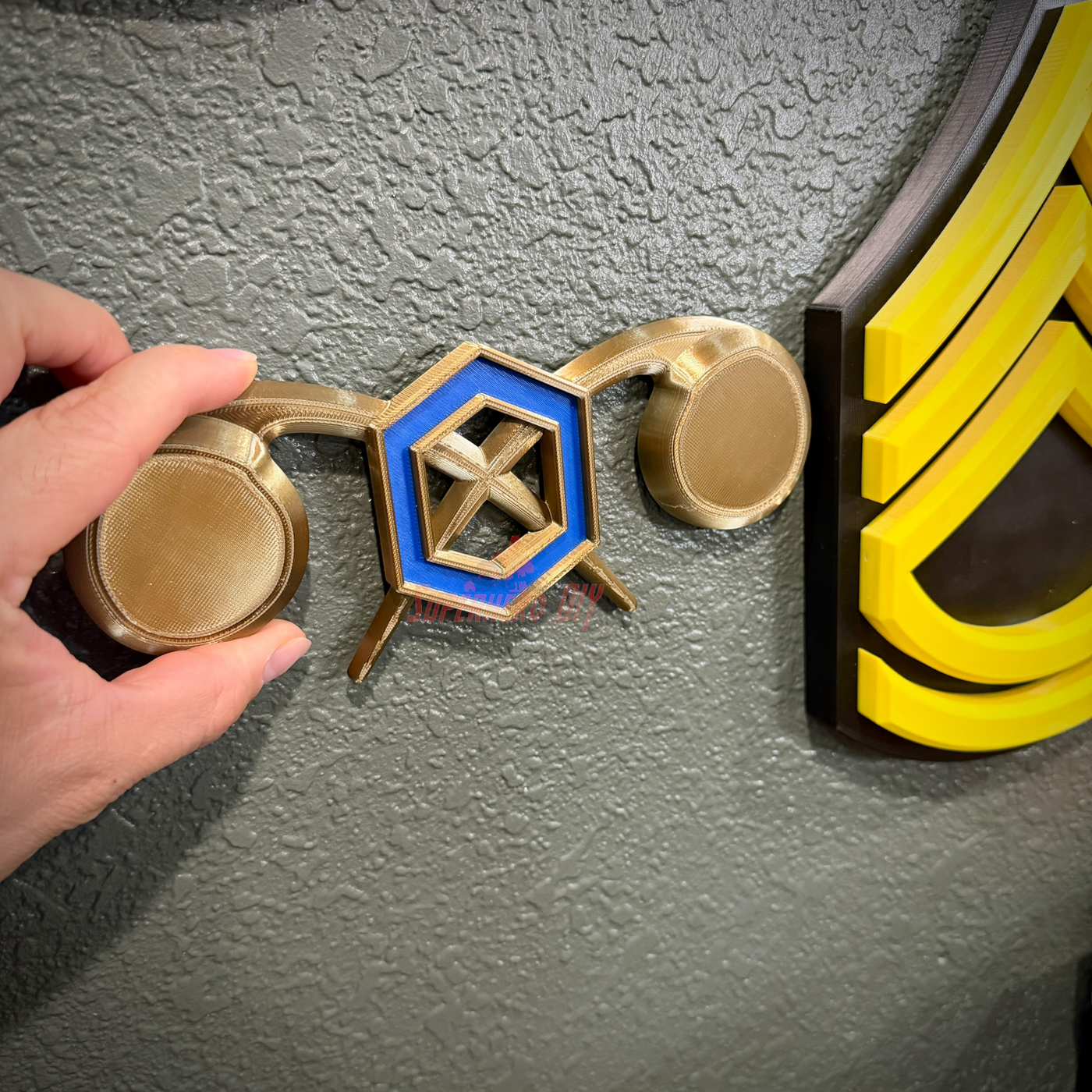 Chemical Corps insignia displayed on a wall, showcasing a cobalt blue benzene ring and crossed gold retorts.