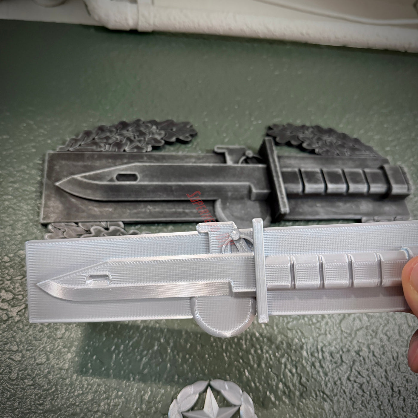 Expert Soldier Badge display with M9 bayonet in silver finish, showcasing detailed craftsmanship and design.
