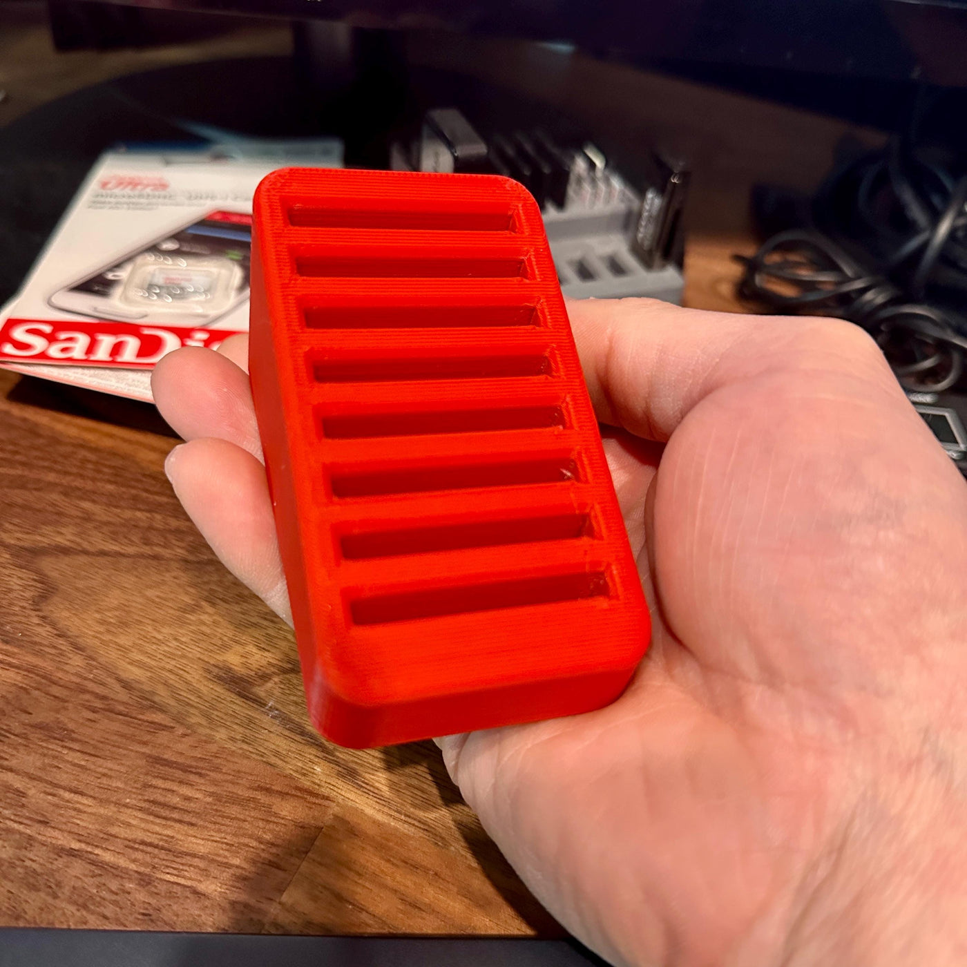 Hand holding a CFexpress Type B card organizer with 8-slot stepped design for convenient storage and access.