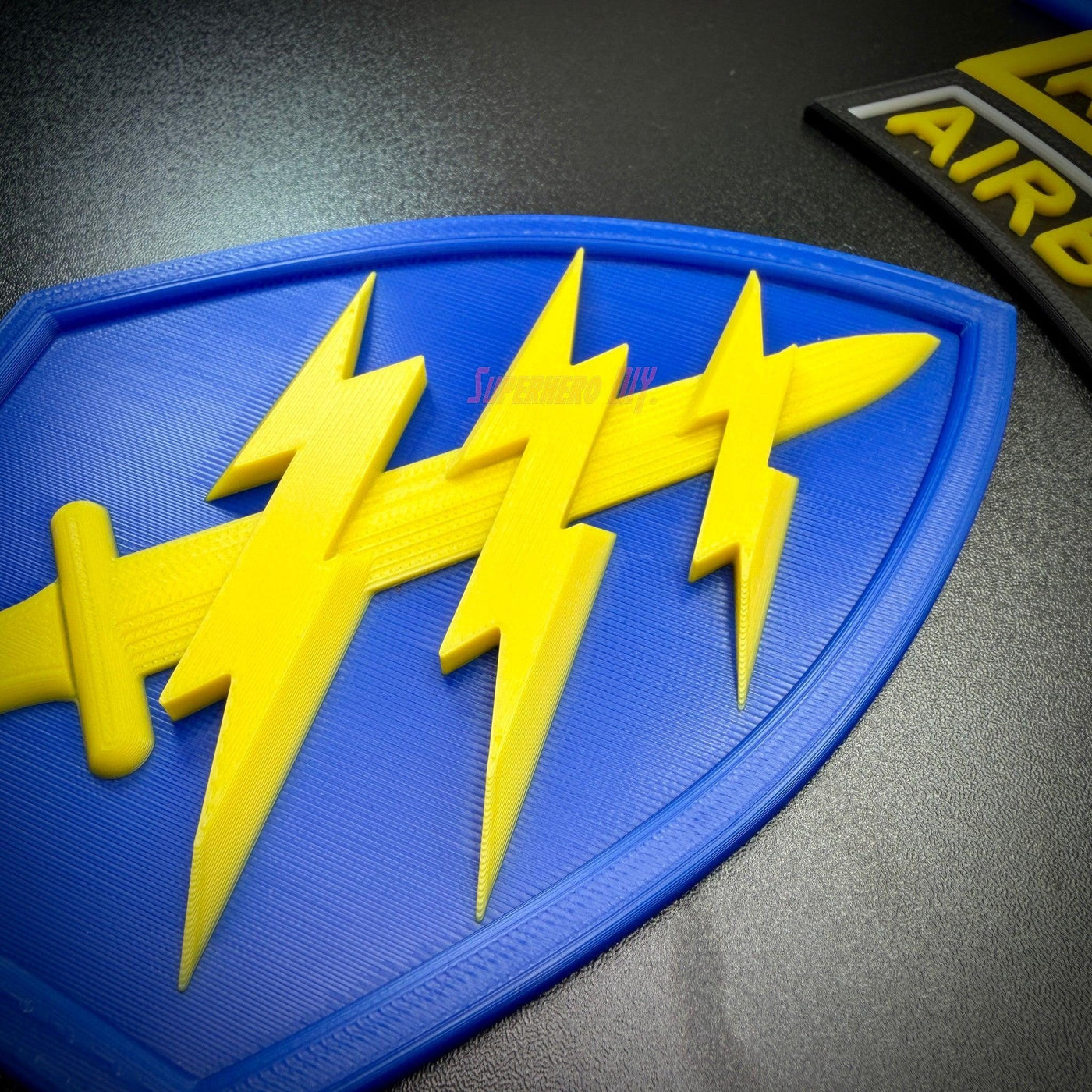 Special Forces display insignia featuring a blue shield with yellow lightning bolts and dagger detail.