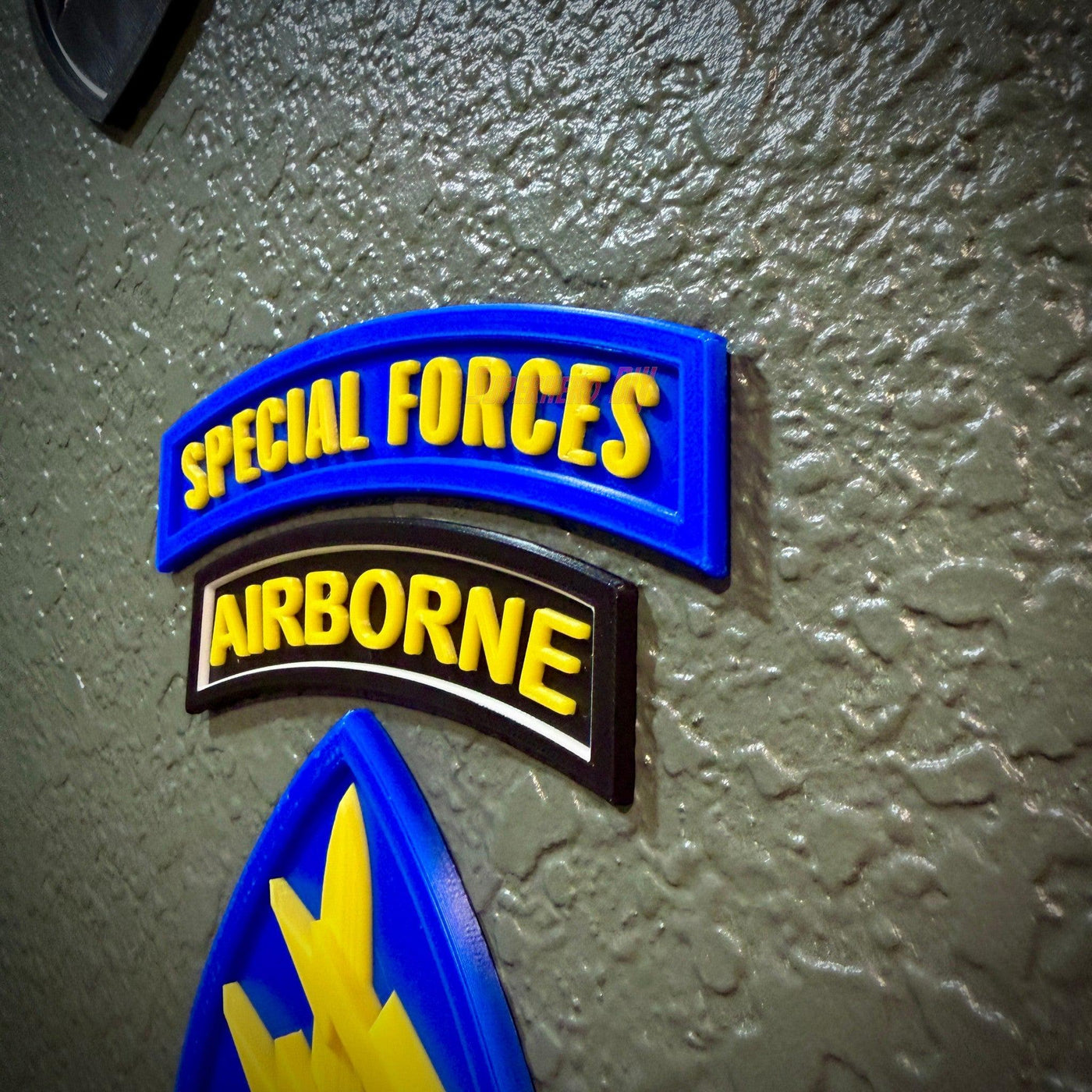 Special Forces display insignia featuring the Airborne and Special Forces tabs on a textured wall background.