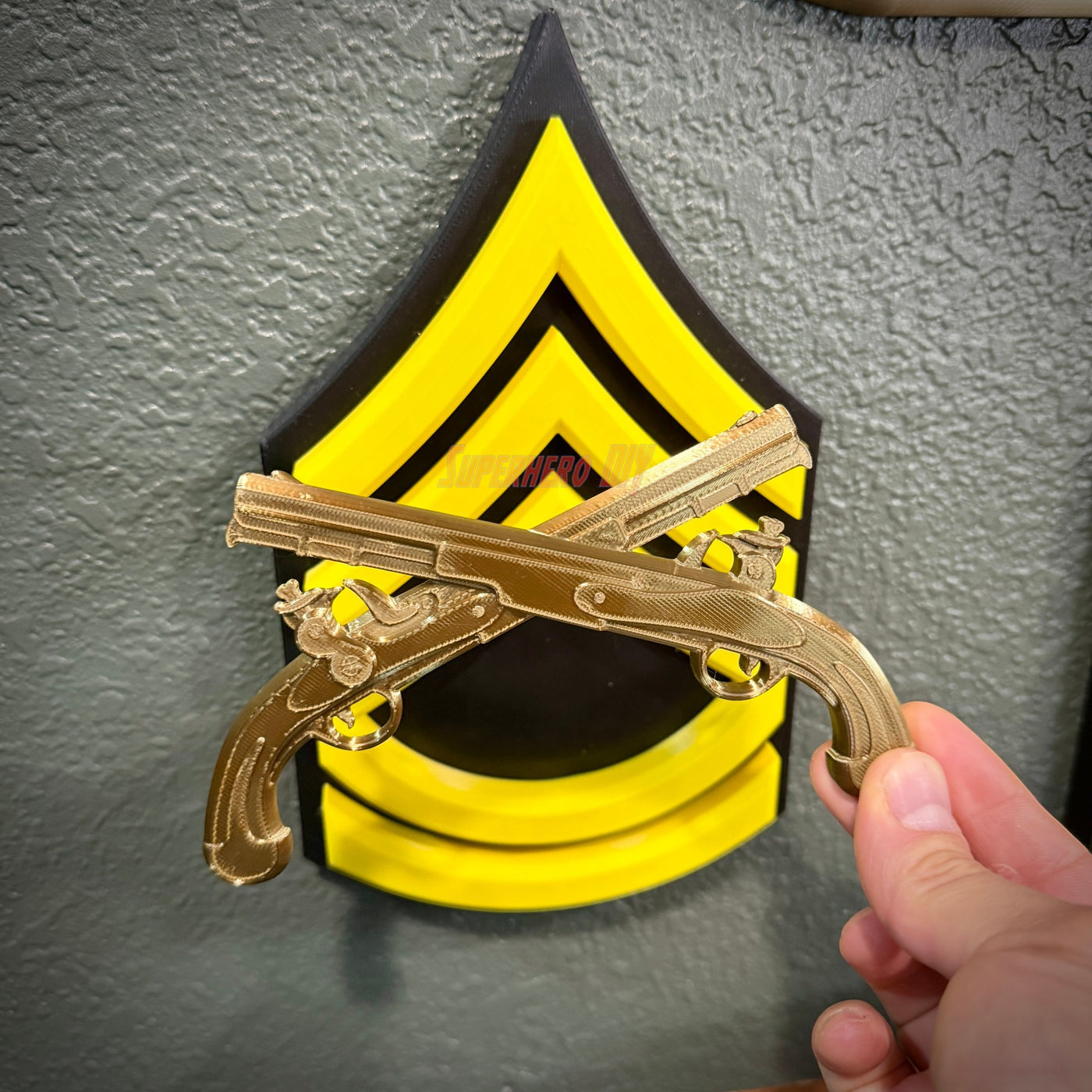 Army military police insignia featuring gold crossed pistols on a black and yellow wall display.