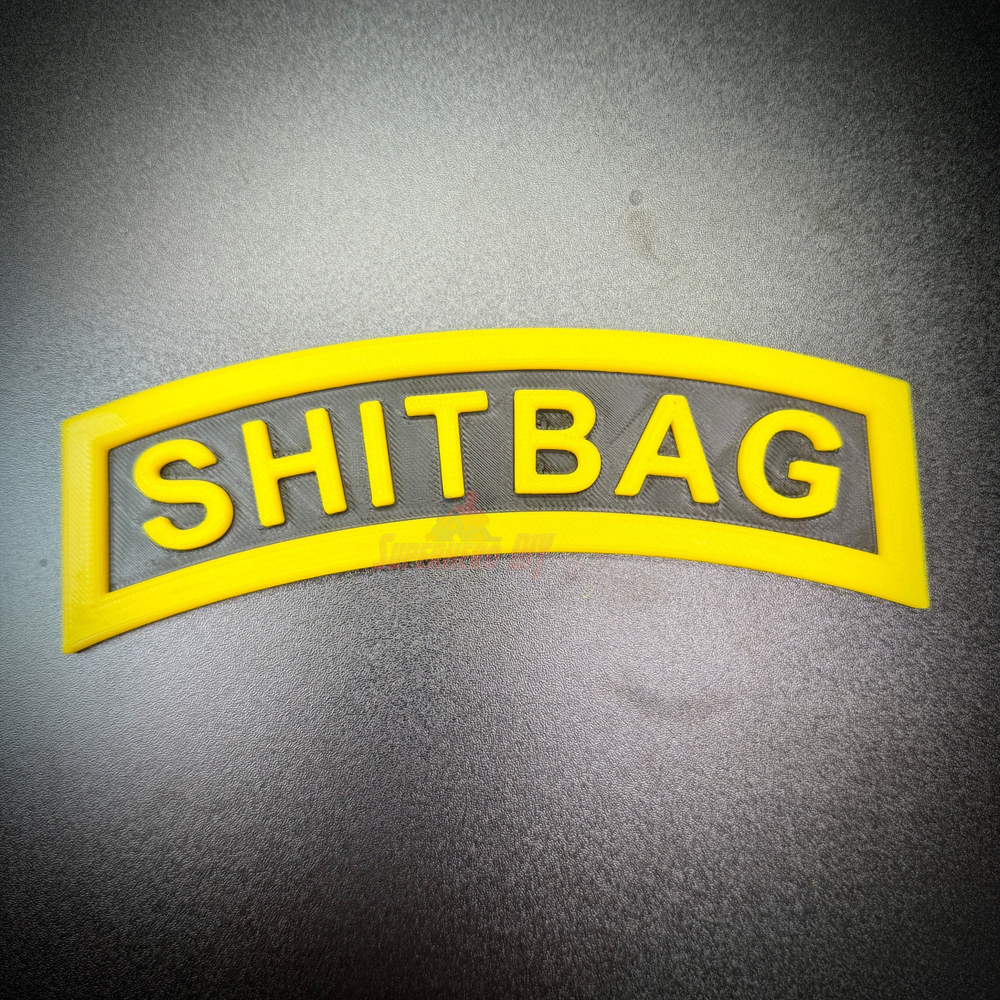 SHITBAG tab in black and yellow, perfect gag gift for soldiers and battle buddies.