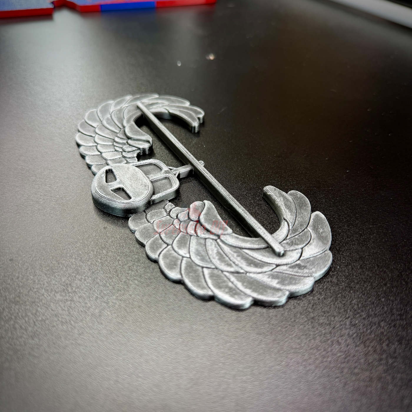 Subdued Air Assault Badge detailed view on a black surface showcasing wings and insignia.