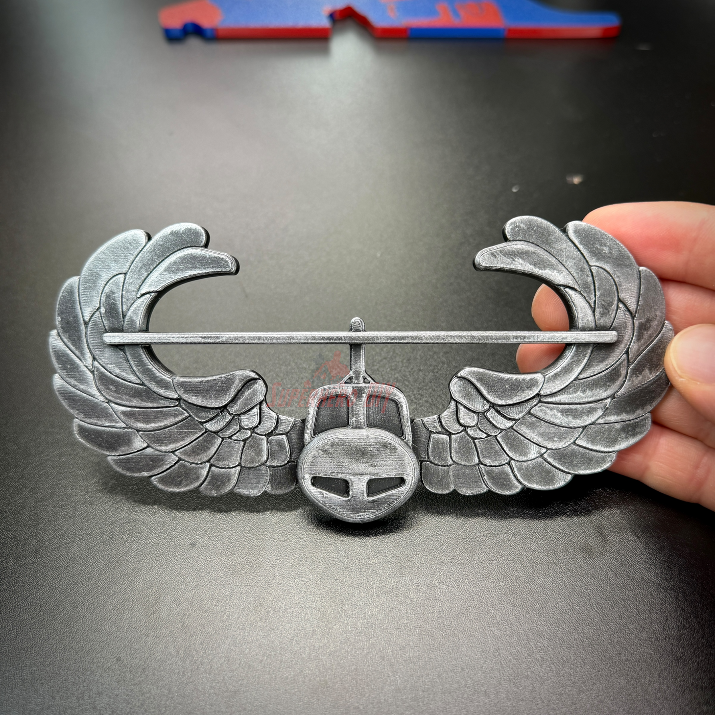 Subdued air assault badge display insignia with detailed wing design in hand.