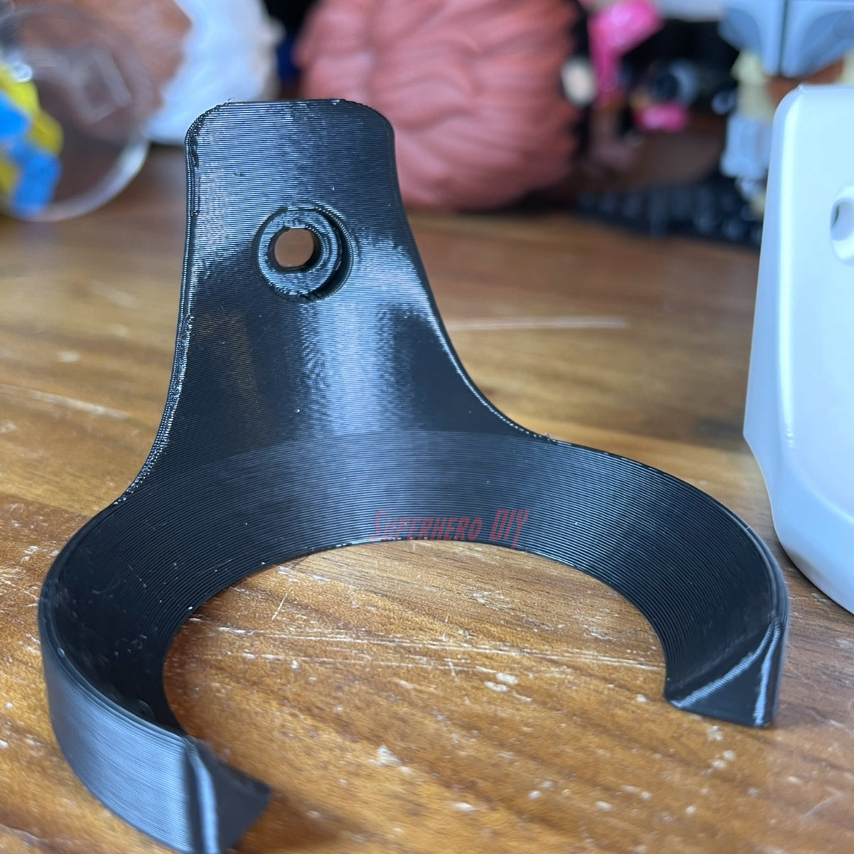 Black baseball holder wall mount attached with a screw, close-up