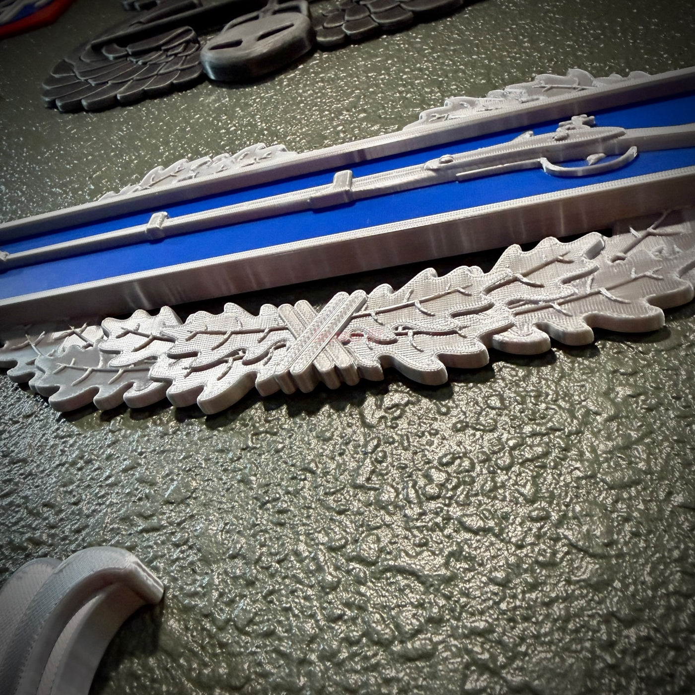 Close-up view of Infantryman Badge replica with infantry-blue bar and detailed oak wreath, showcasing the combat infantryman badge.