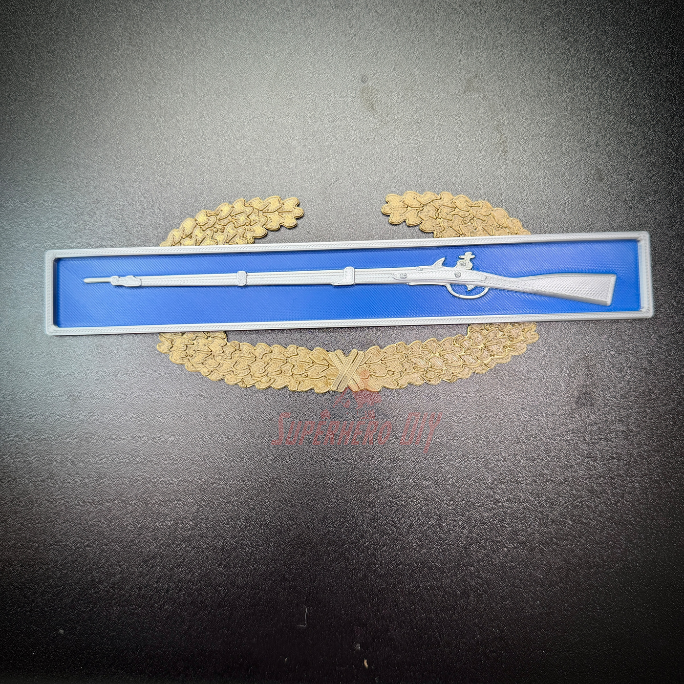Master Combat Infantryman Badge 3D-printed replica displayed with a rifle in a presentation case.
