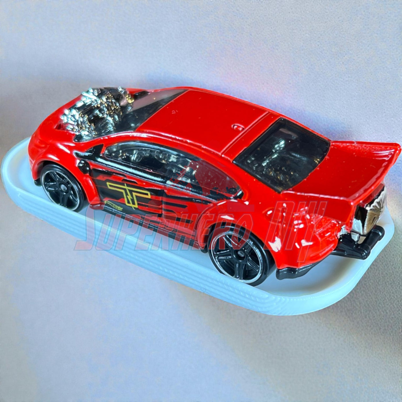 Red Hot Wheels car on display shelf for hot wheels with command strip