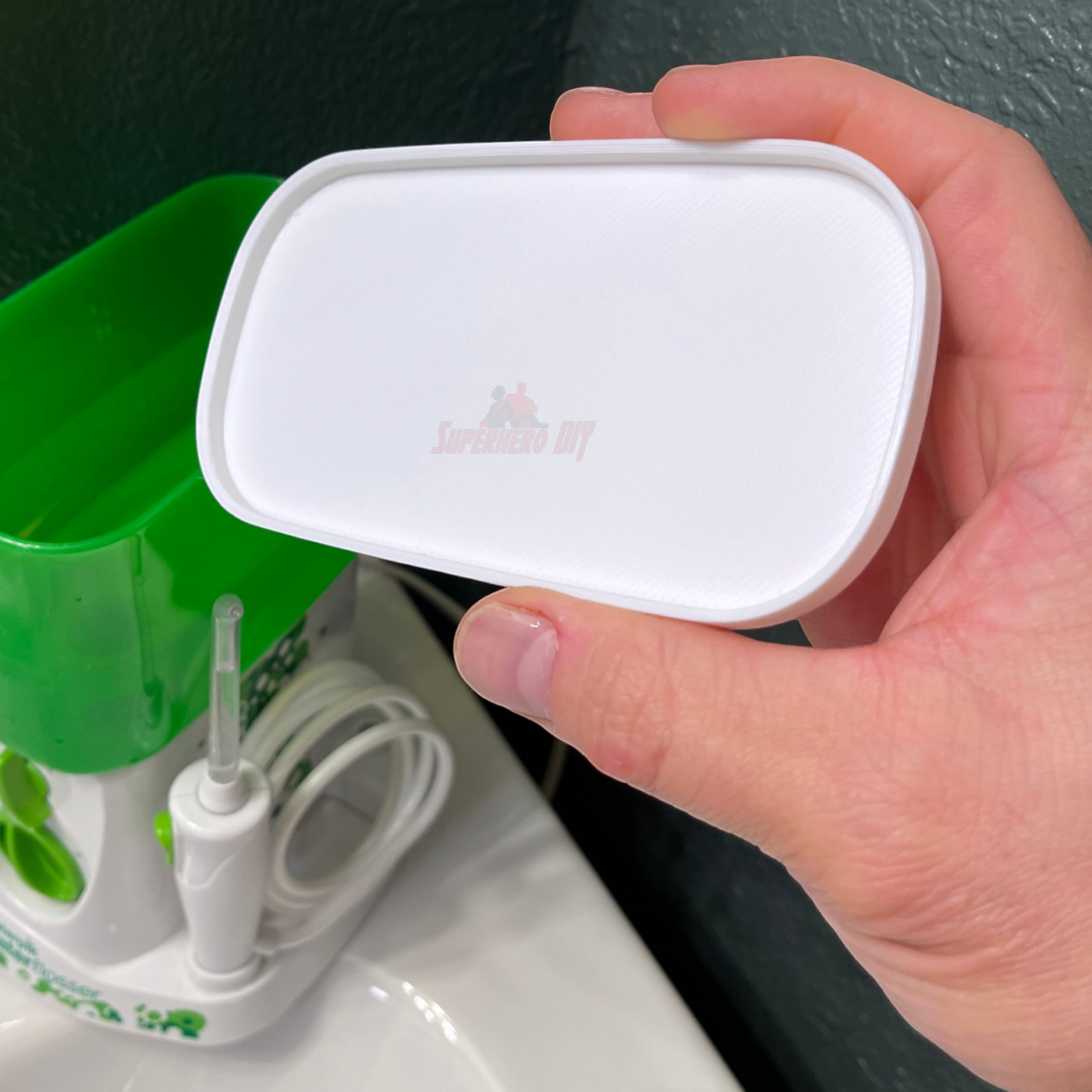 Lid for Waterpik Traveler Water Flosser WP-300 held in hand, covering the water tank to keep it clean.
