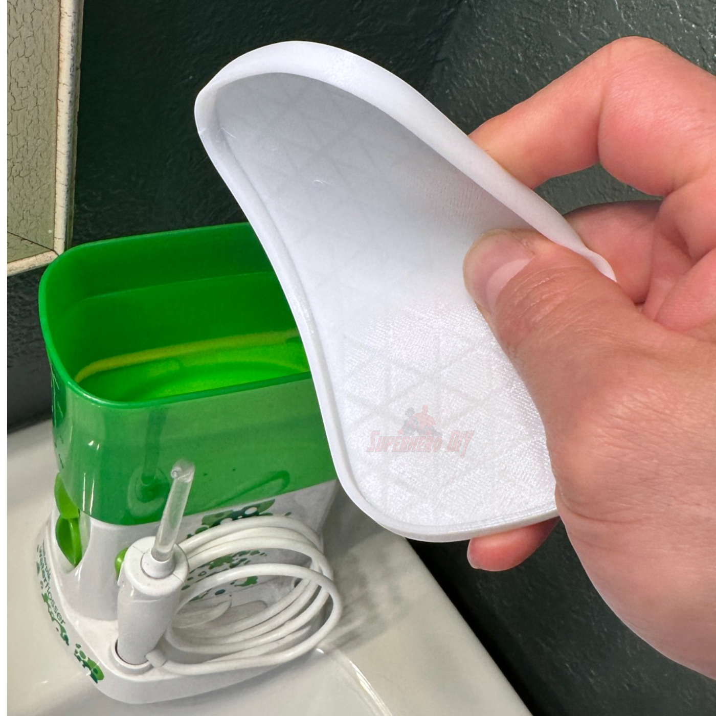 Lid for Waterpik Traveler being held over the water tank of a Waterpik Traveler Water Flosser WP-300.