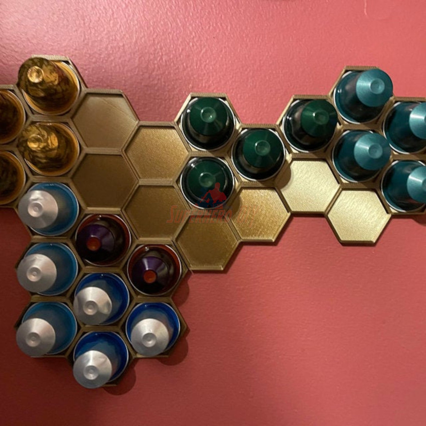 Honeycomb wall mount displaying original Nespresso coffee pod organizer holding colorful capsules on a wall.