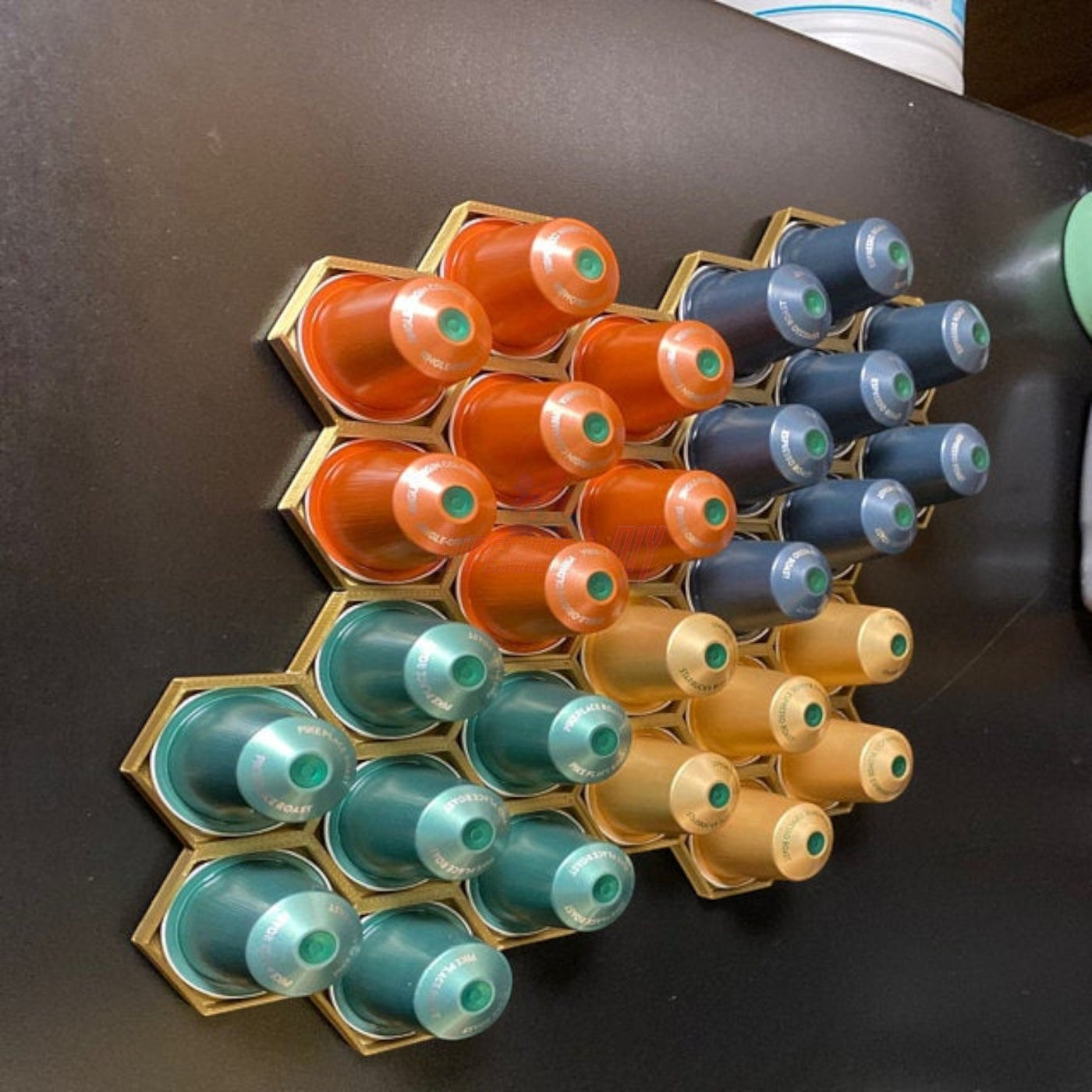 Honeycomb wall mount displaying original nespresso coffee pod organizer with colorful capsules in hexagonal arrangement.