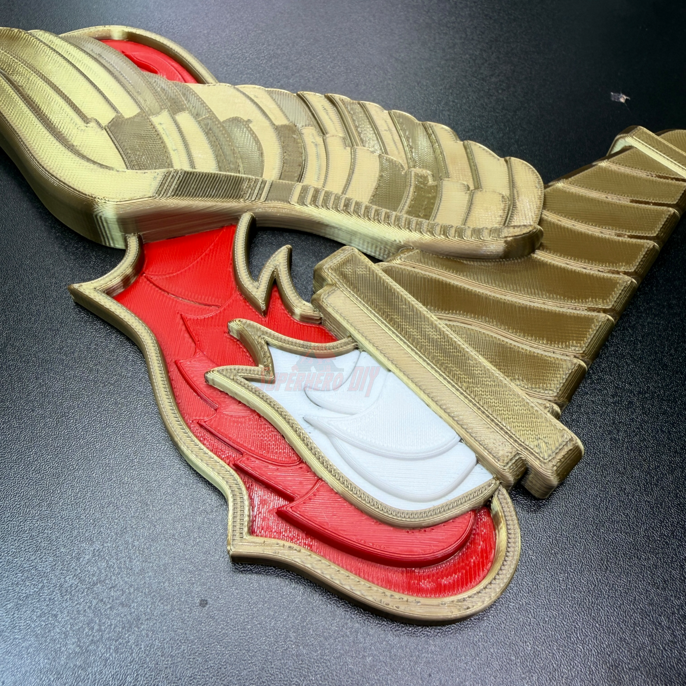 Army Pathfinder Badge display insignia in red, gold, and white finishes laid out on a black surface.