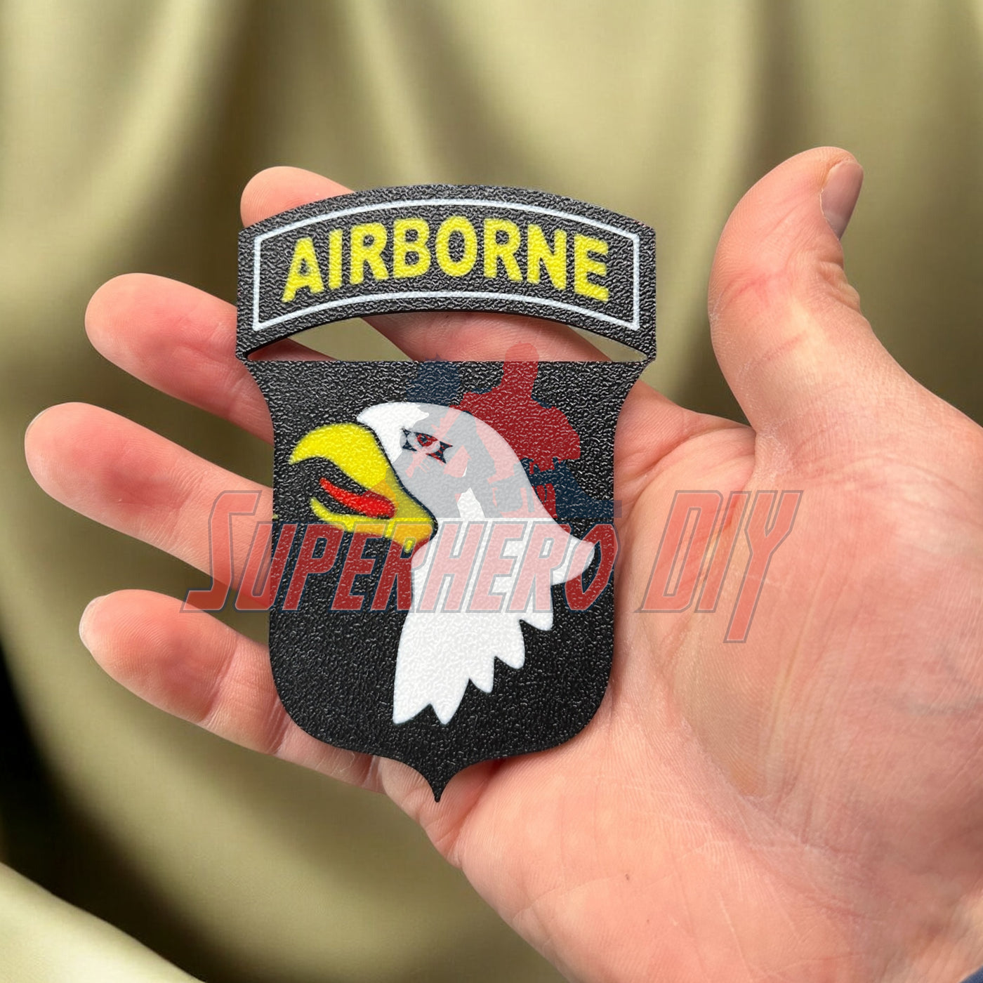 Hand holding 101st Airborne Division display insignia, 3D-printed badge honoring U.S. Army unit.