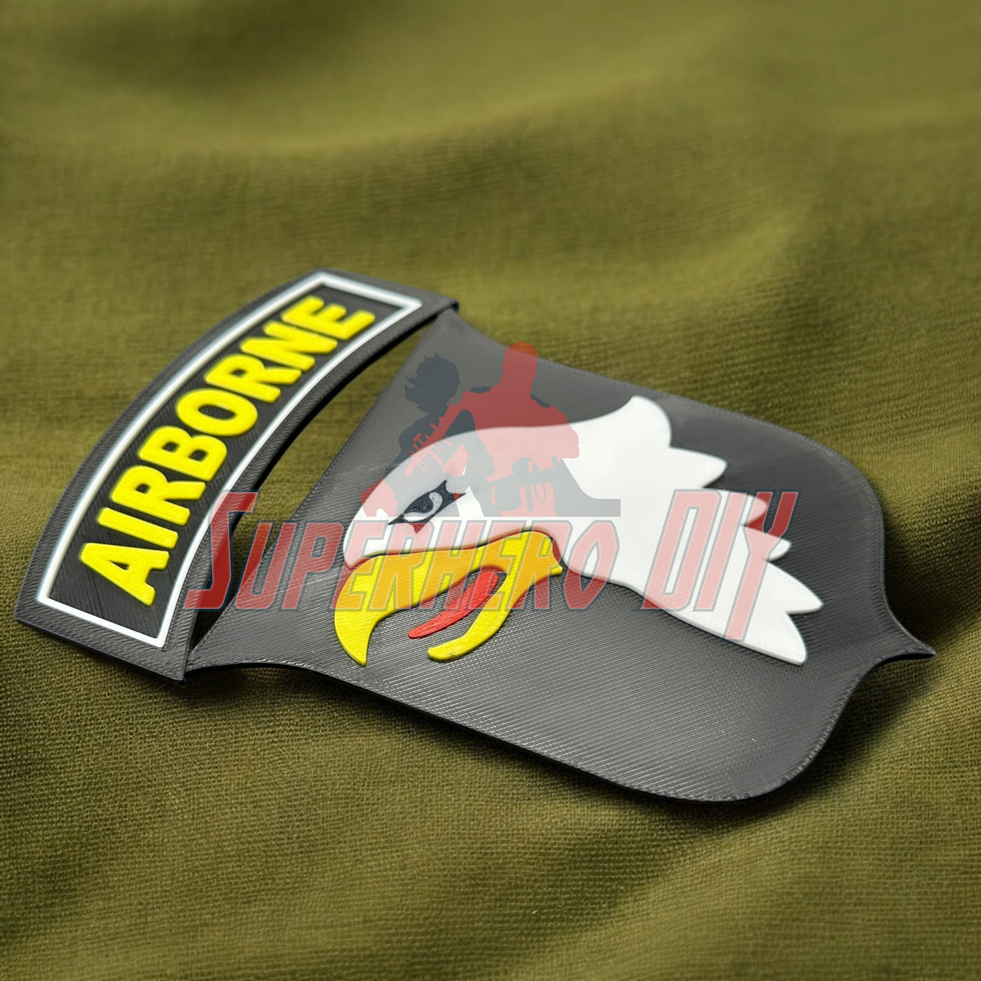 3D-printed 101st Airborne Division display insignia on green fabric background
