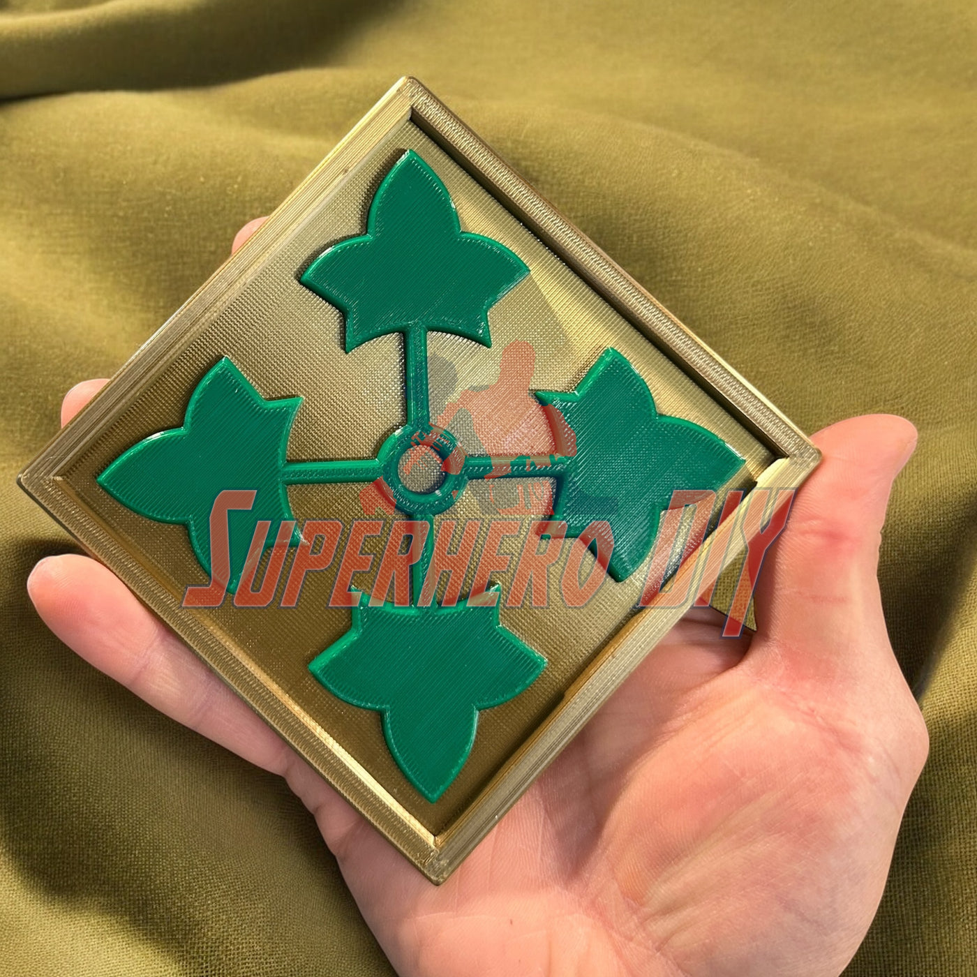 Close-up of the 4th Infantry Division display insignia with green ivy leaf design, 3D-printed by a U.S. Army veteran.