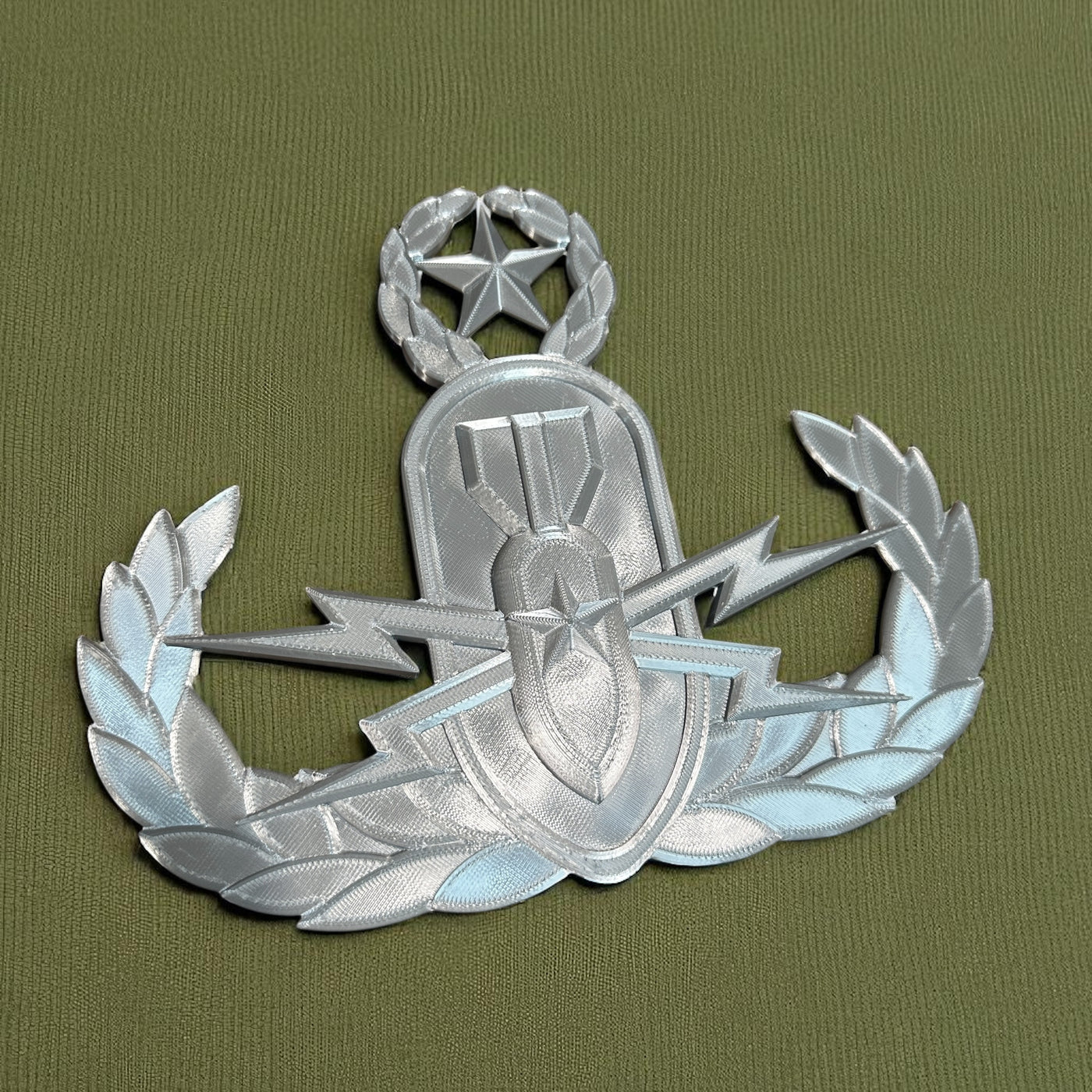 Replica EOD Badge Display on textured green fabric background