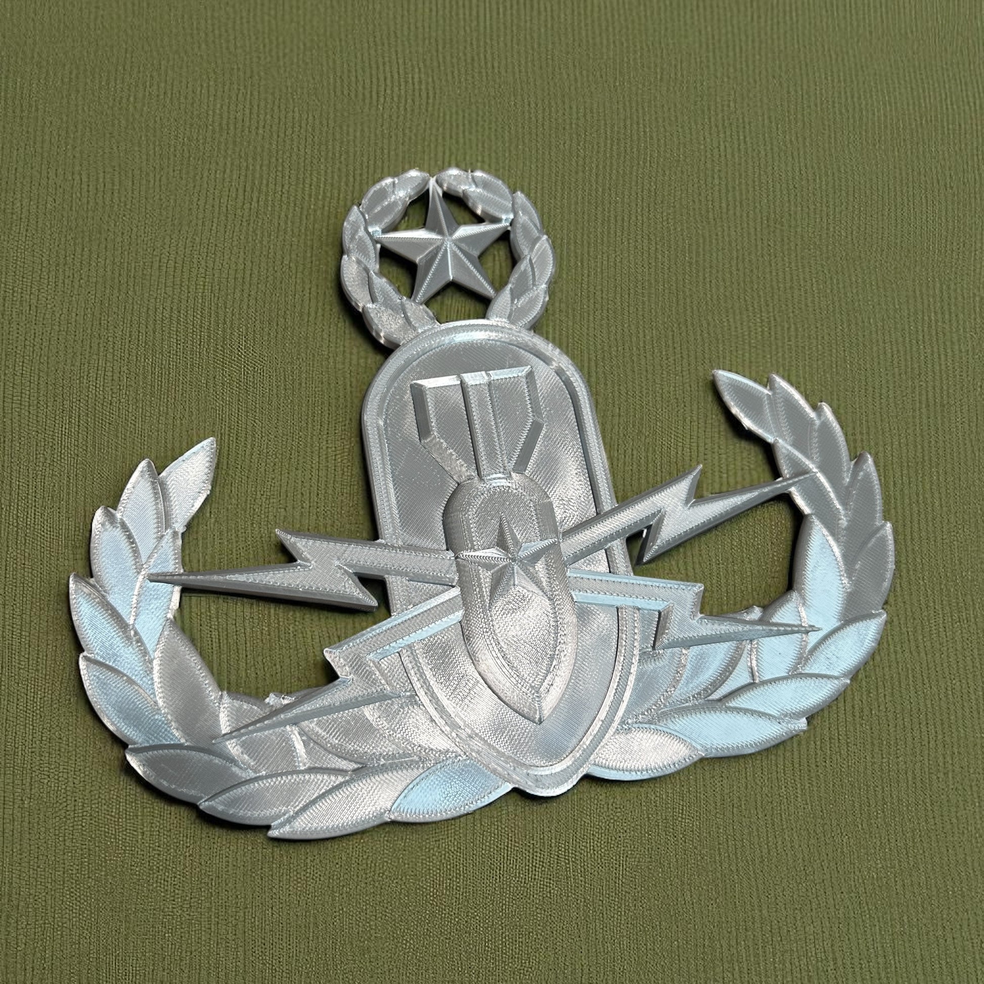 Replica EOD Badge Display on textured green fabric background