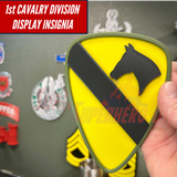 1st Cavalry Division Display Insignia in hand near various military decor items.