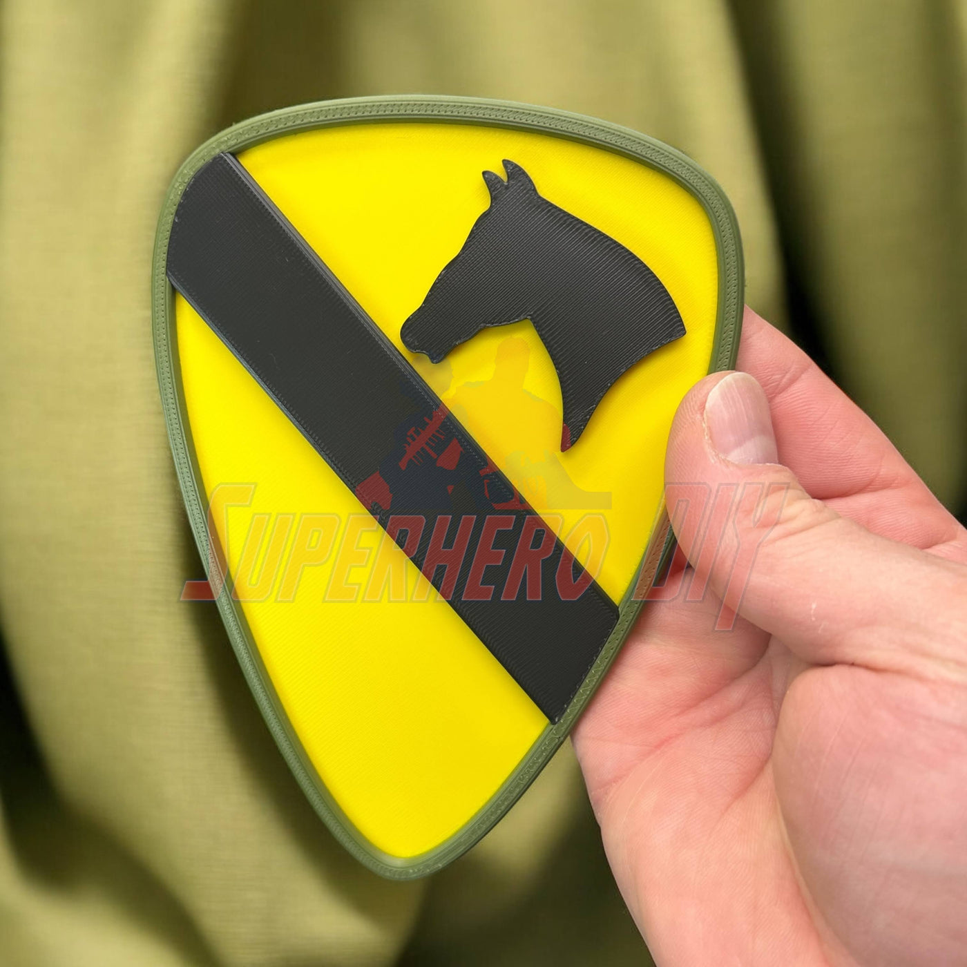 Close-up of 1st Cavalry Division Display Insignia held in hand, showcasing the distinct yellow and black design.