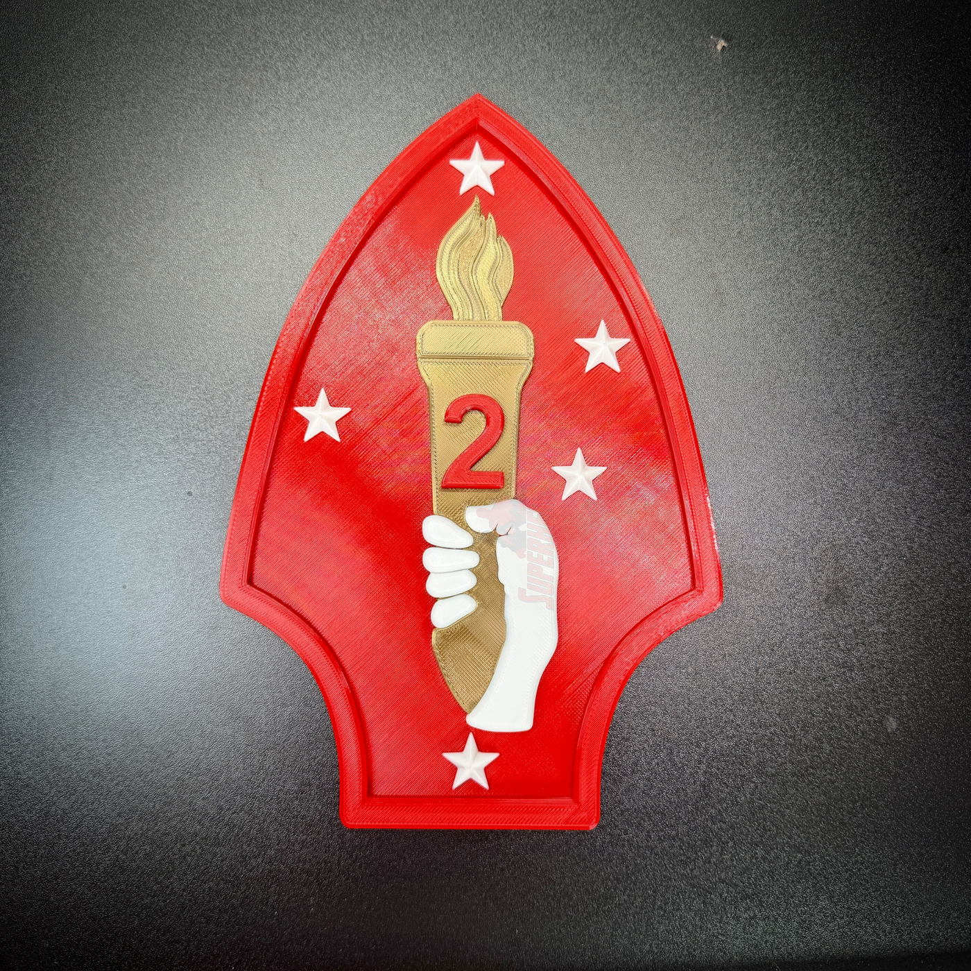 2nd Marine Division display insignia featuring red spearhead, gold torch, and Southern Cross stars.