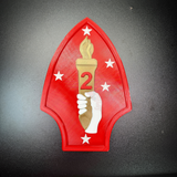 2nd Marine Division display insignia featuring red spearhead, gold torch, and Southern Cross stars.