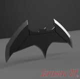 Black bat-shaped object with angular wings and a small bat emblem in the center on dark background. - SuperheroDIY