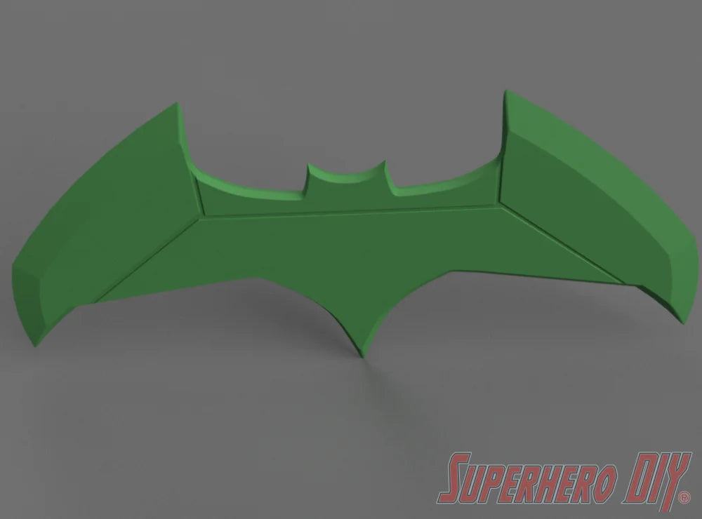 Green bat-shaped model with pointed wings and a central bat symbol cutout against a gray background. - SuperheroDIY